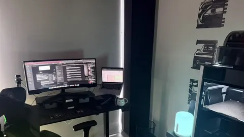 Mesa de trabalho com monitores em um escritório escuro