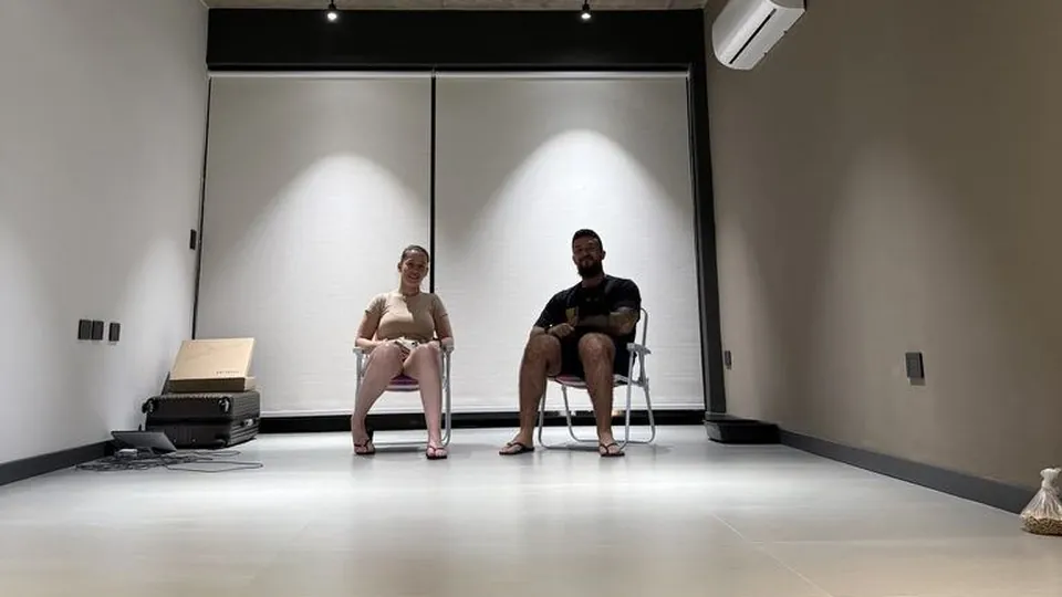 Duas pessoas conversando sentadas em uma sala ampla e clara