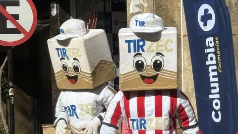 Dois mascotes fantasiados na calçada, um com camisa listrada vermelha e branca