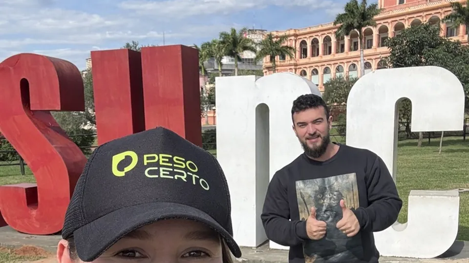 Pâmela de boné em primeiro plano e Samuel ao fundo, com o Palacio de los López atrás, em Assunção