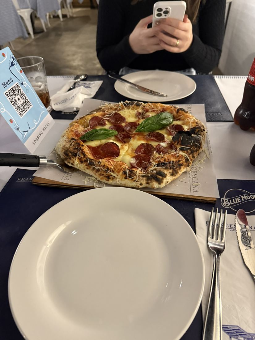 Pizza de pepperoni e manjericão em uma mesa de restaurante